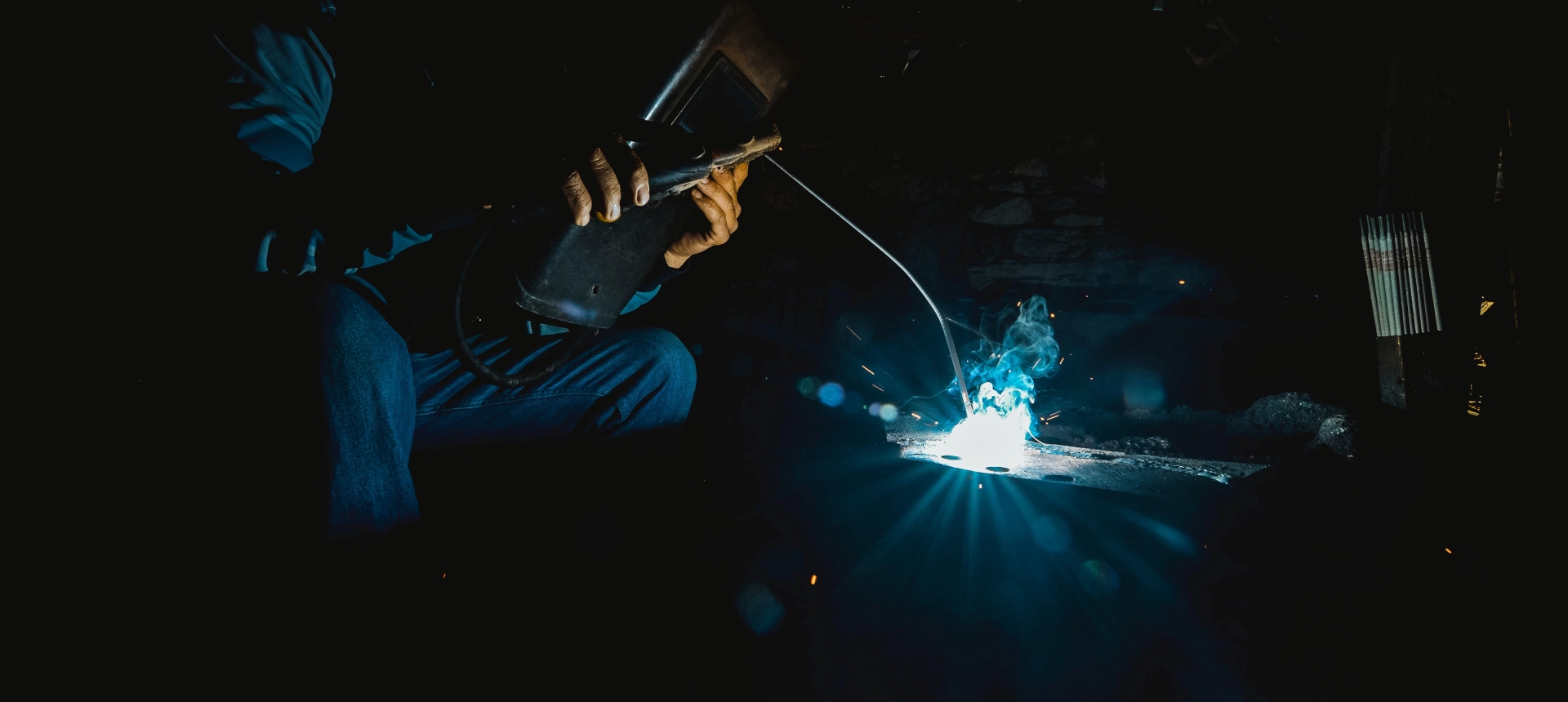 Man welding with a blue flame